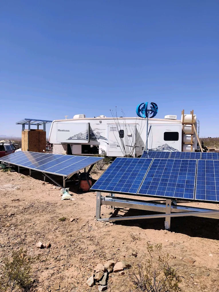 Ground-mounted off-grid solar array powering an RV in the Arizona desert