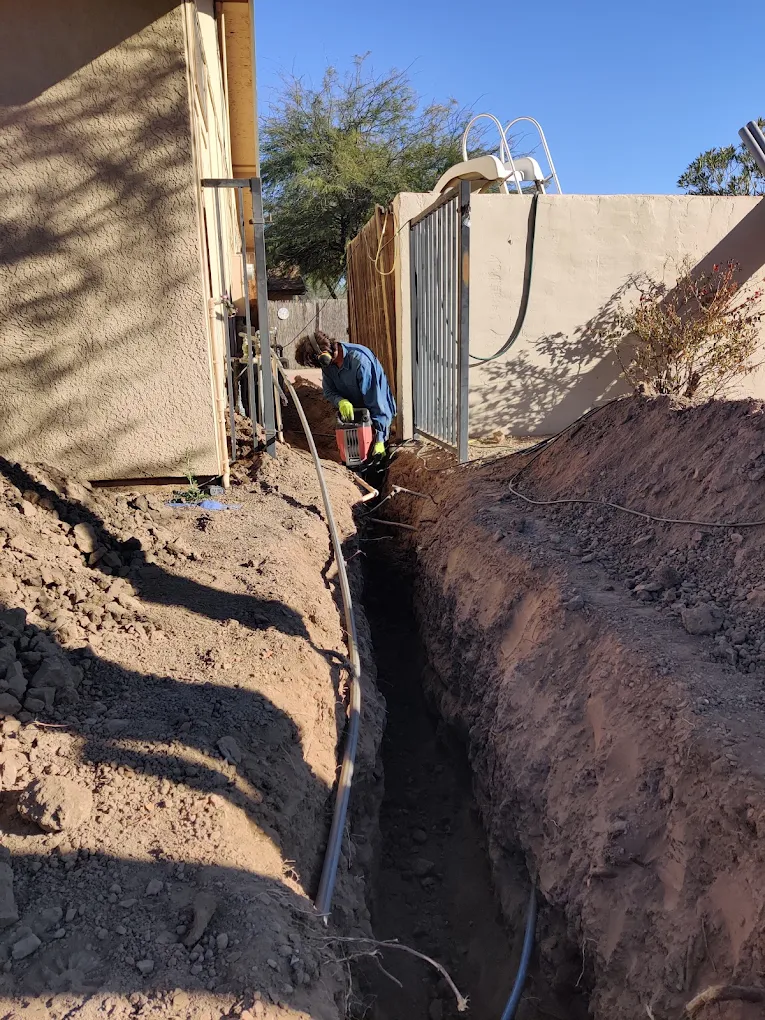 Long trench dug along a block wall for an underground electrical line